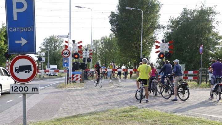 Wandelaars, fietsers en auto’s wachten voor de spoorbomen. (Foto: De Vries Media)