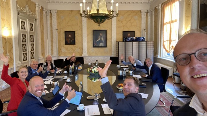 Friso Douwstra (rechts) wordt uitgezwaaid door collega’s tijdens zijn laatste collegevergadering.