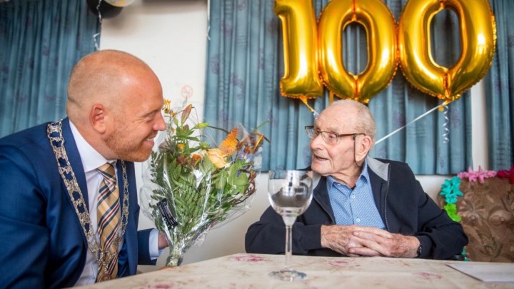 Loco-burgemeeter Hein de Haan (links) bracht de 100-jarige IJde Jonker een bloemetje.