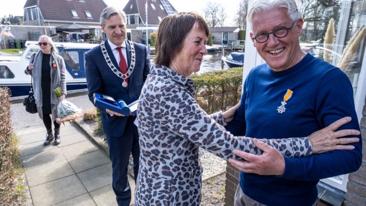 Burgemeester Buma heeft Jan Bijlsma onderscheiden. Zijn vrouw speldde hem de versierselen op. (Foto: Mark Grupstra)