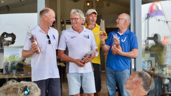 Durk Talsma van KWV Frisia  (in geel shirt) deelt de wisselprijs uit aan een bestuurslid van het Jouster skûtsje.